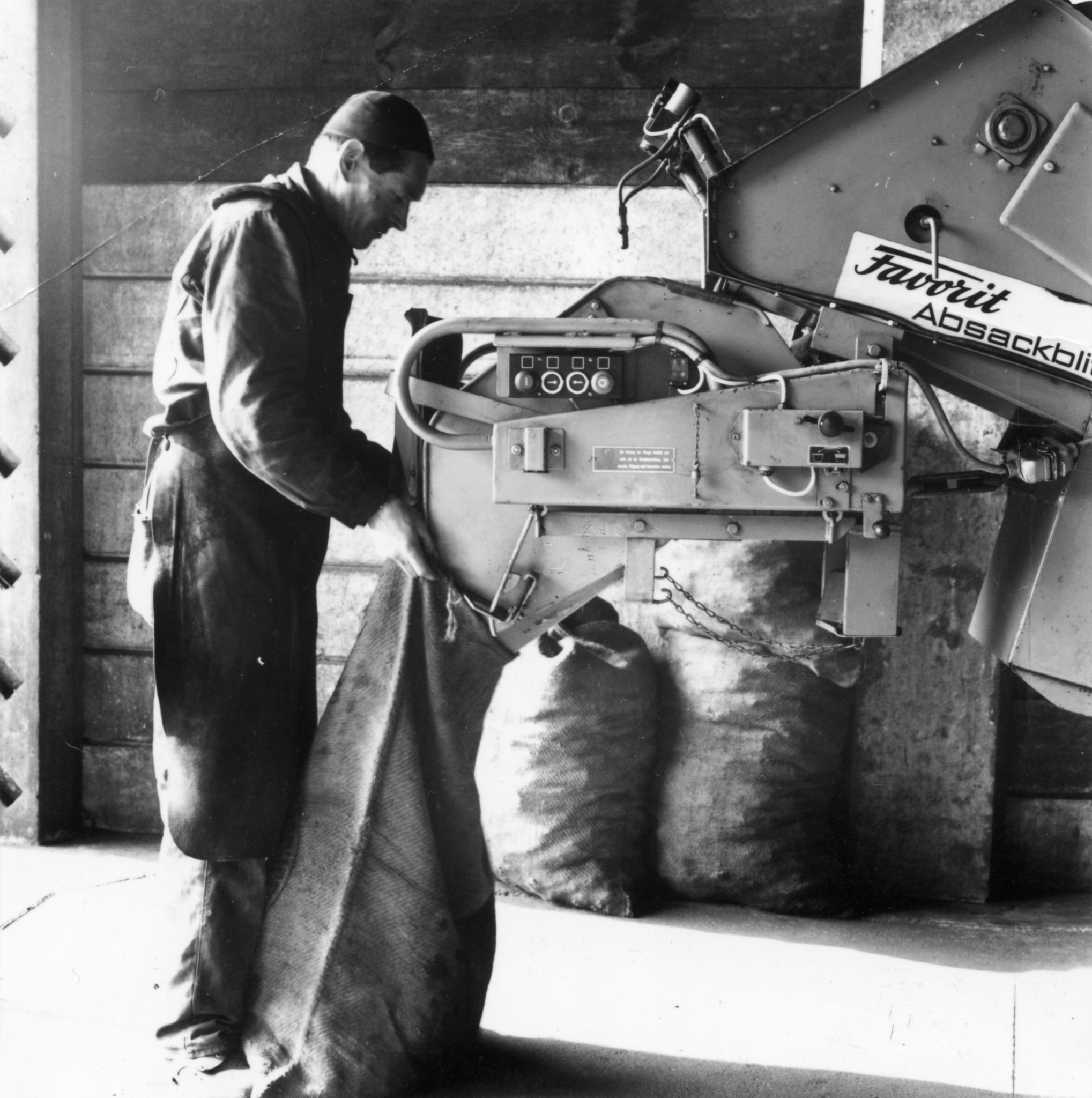 Mann arbeitend an Maschine zum Verpacken von Säcken