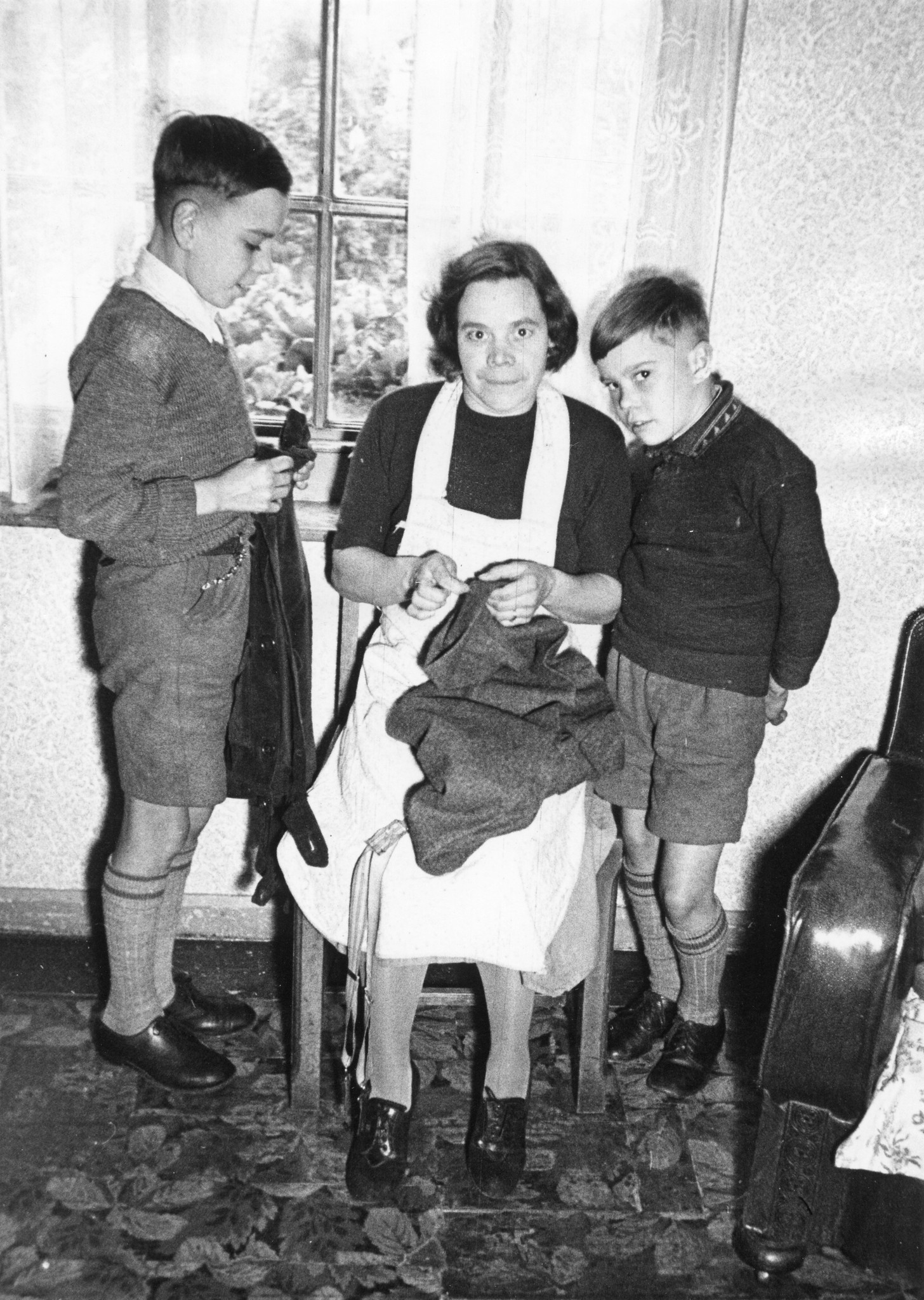 Eine Mutter bereitet die Kleider ihrer Söhne für die Reise vor