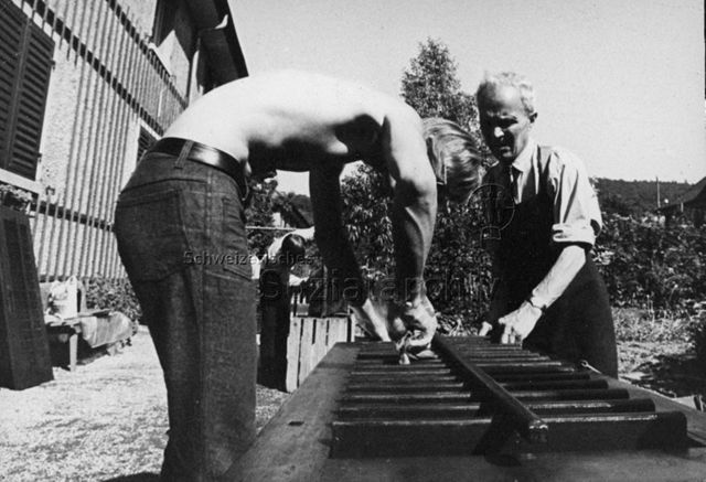 "Aktion 7" - Jugendlicher und Mann beim Restaurieren alter Fensterläden; um 1980