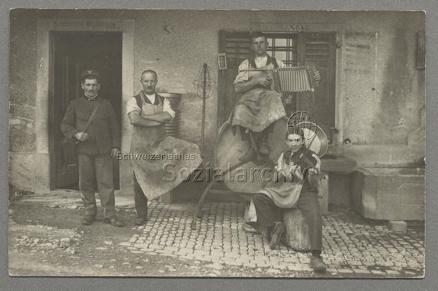 Ein Postbote in Uniform und drei Käser mit Geige und Schwyzerörgeli vor "Sennerei Etzliberg", Thalwil (?) um 1910