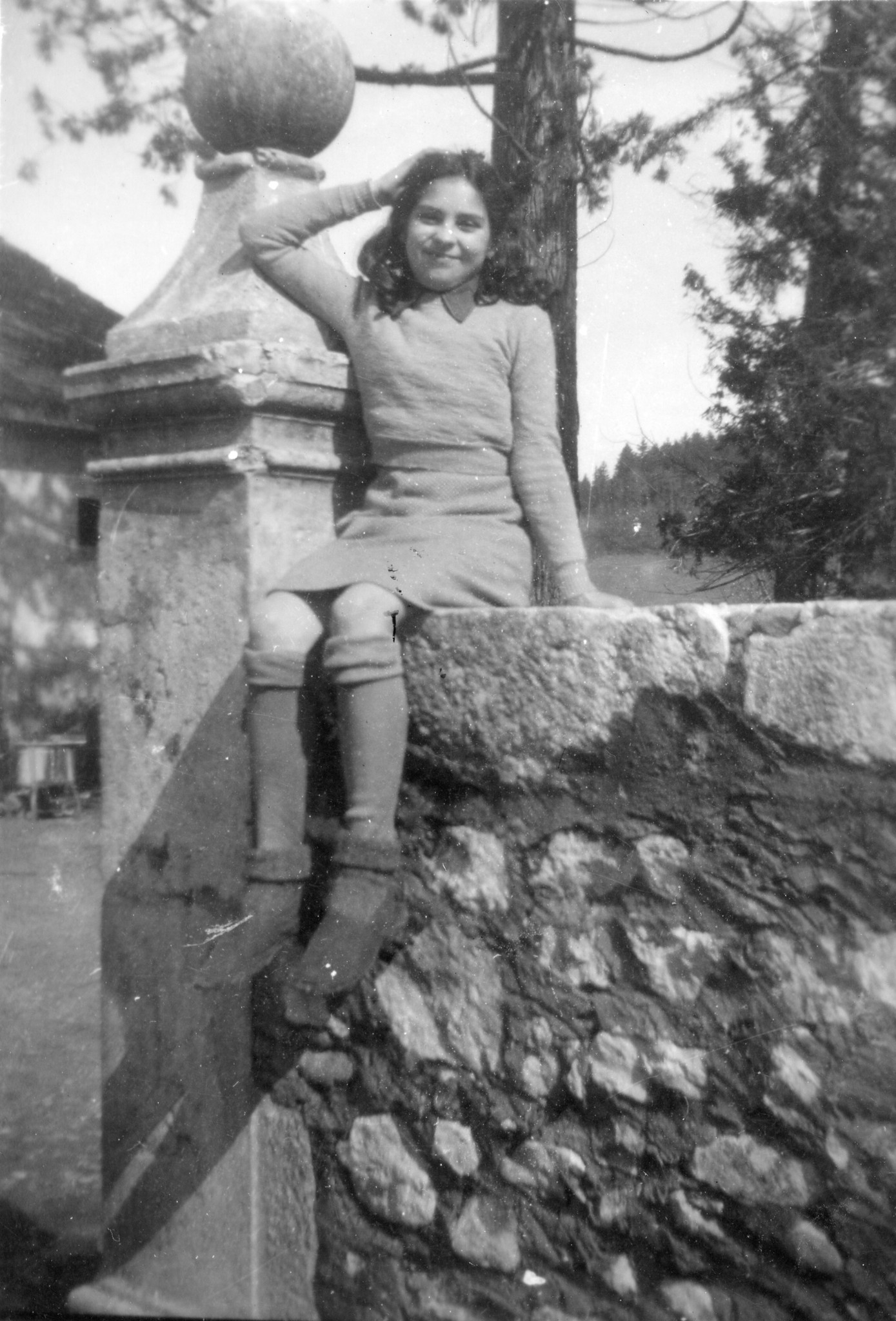 "Hèlène Abad"; ein Mädchen sitzt auf einer Mauer