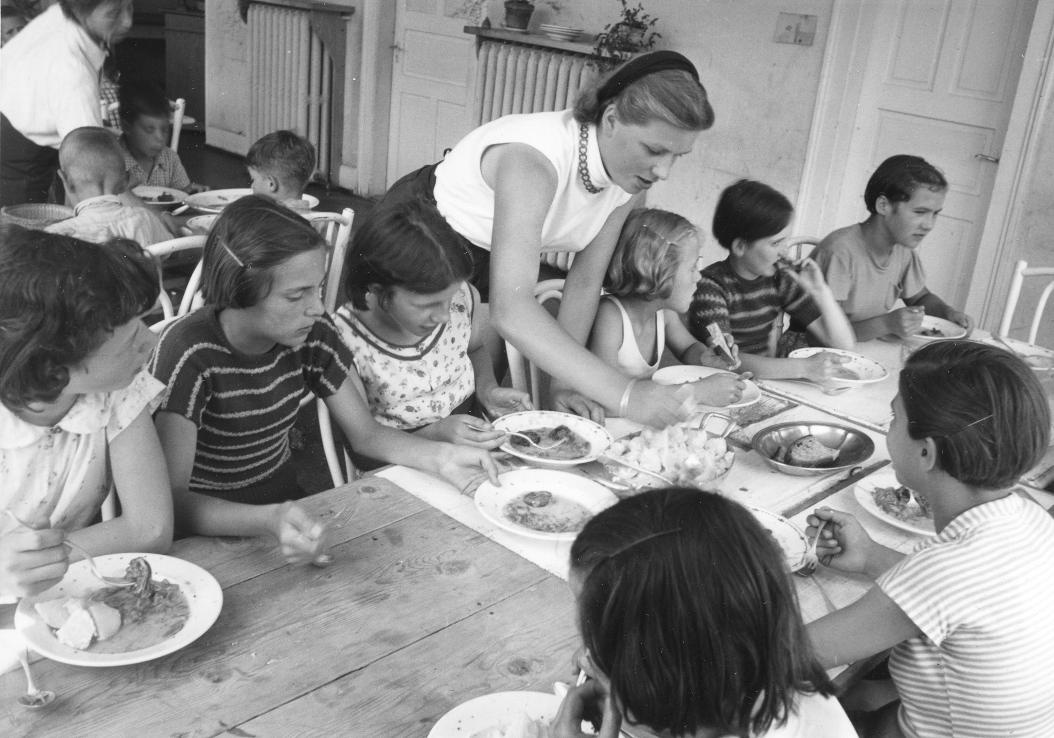 Erzieherin die Kinder beim Essen betreuend