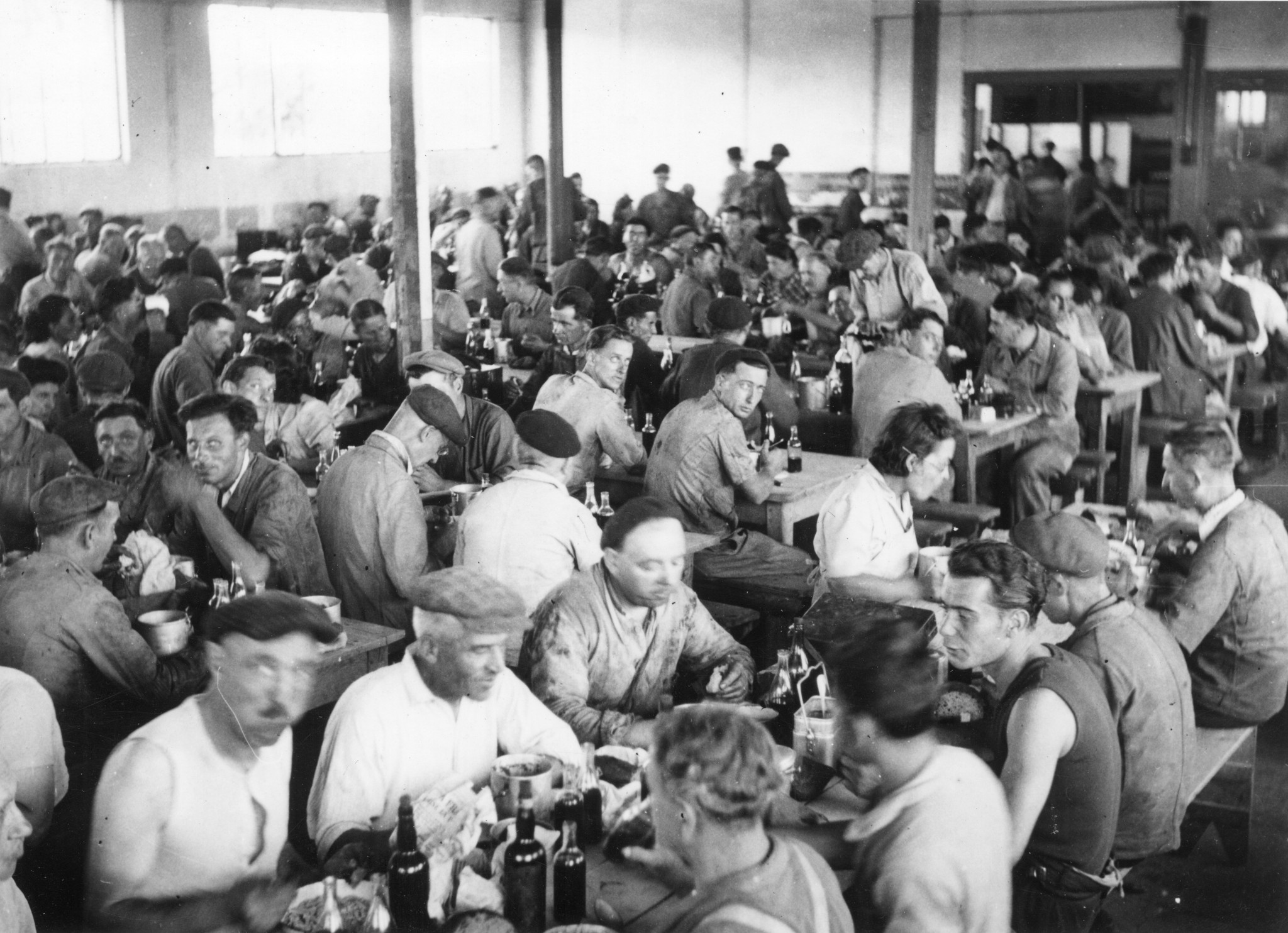 "Lyon 1945. SOMUA-Arbeiter beim Mittagessen in der Kantine." Société d'Outillage Mécanique et d'Usinage d'Artillerie (SOMUA), Unternehmen der Rüstungs- und Kraftfahrzeugindustrie