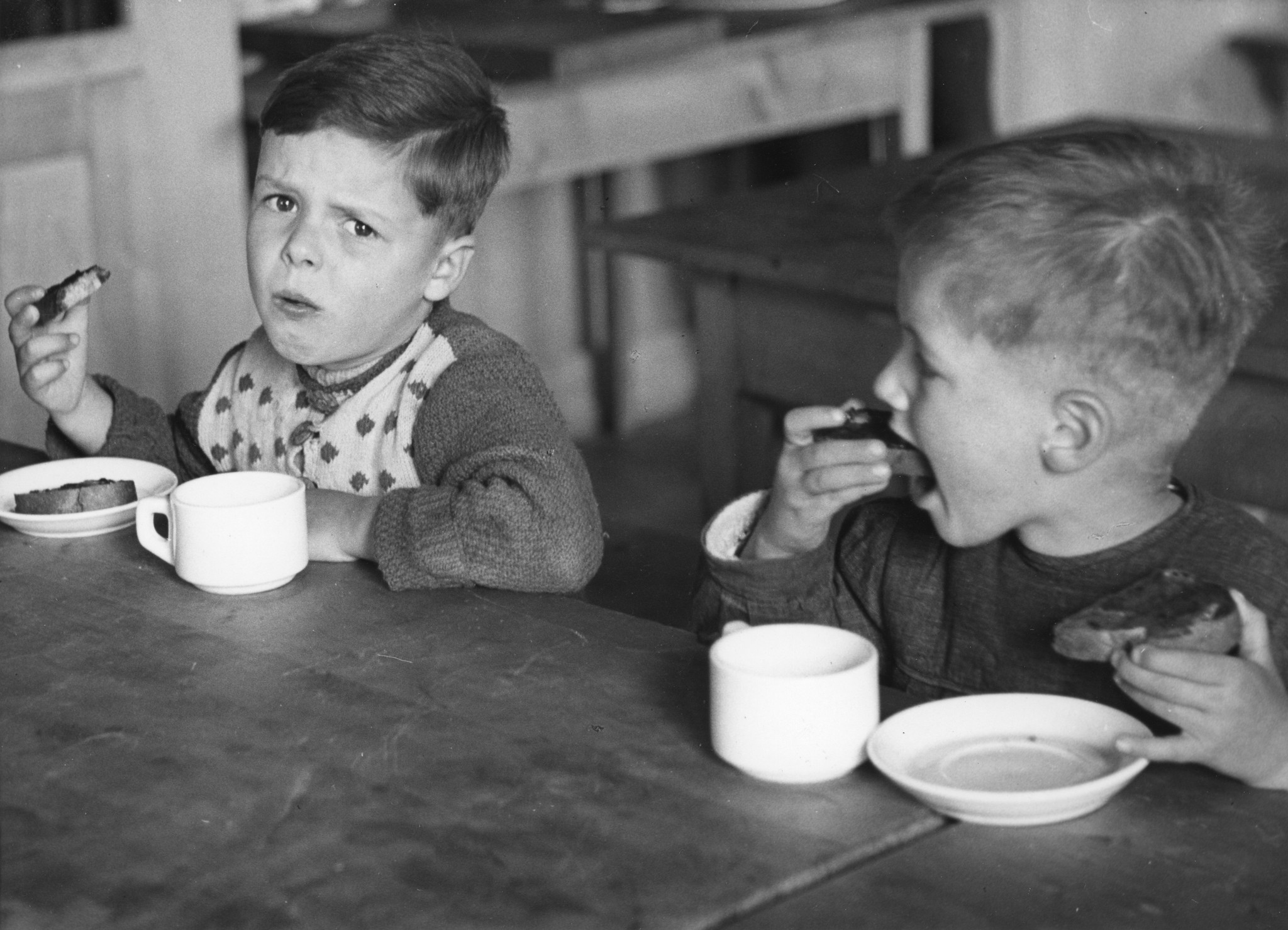 Zwei Knaben sitzen an einem Tisch und frühstücken
