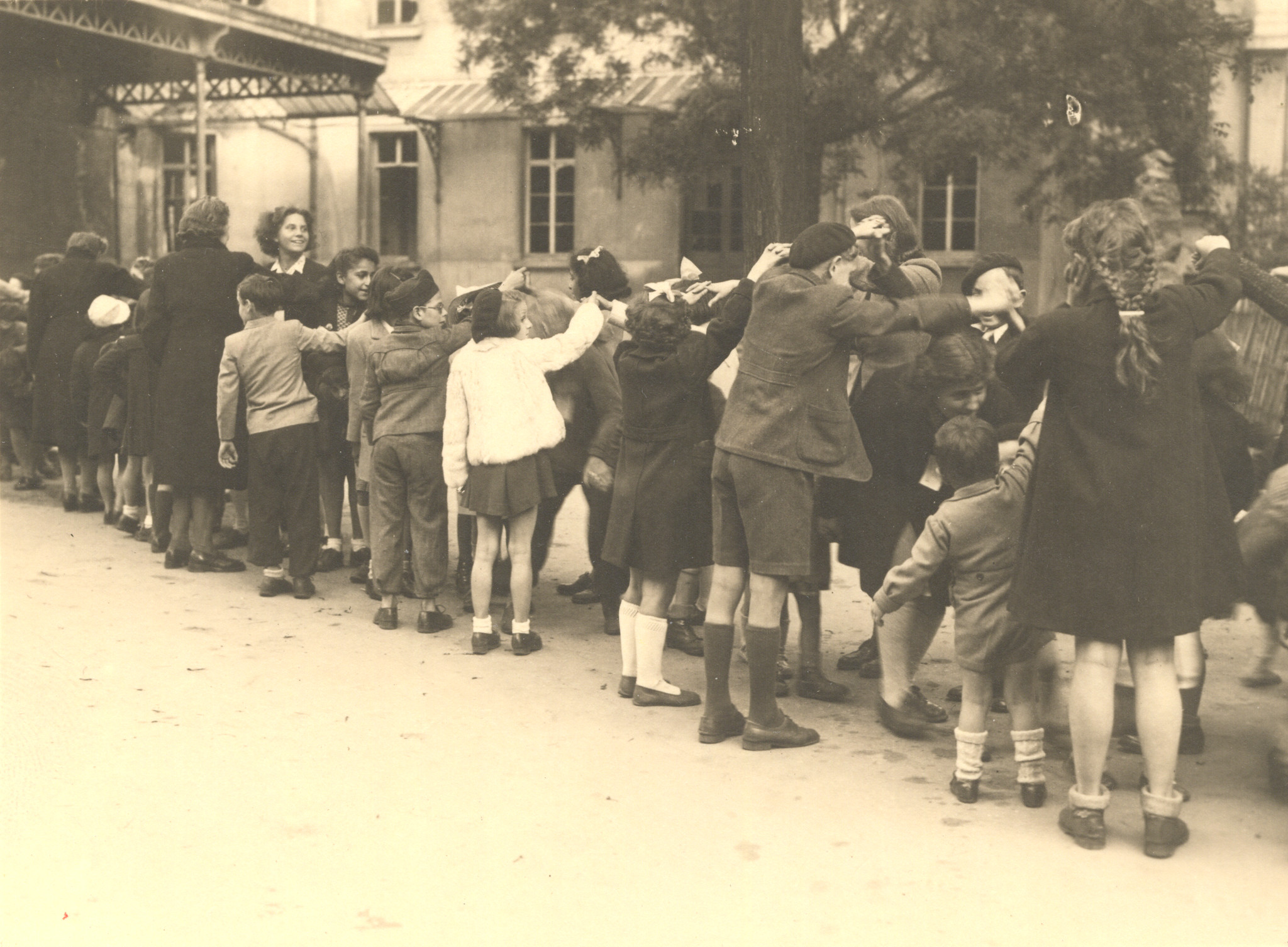 "Lyon, Herbst 1944, Kinder an einem Fest der SAH." Kinder beim Spalierspielen