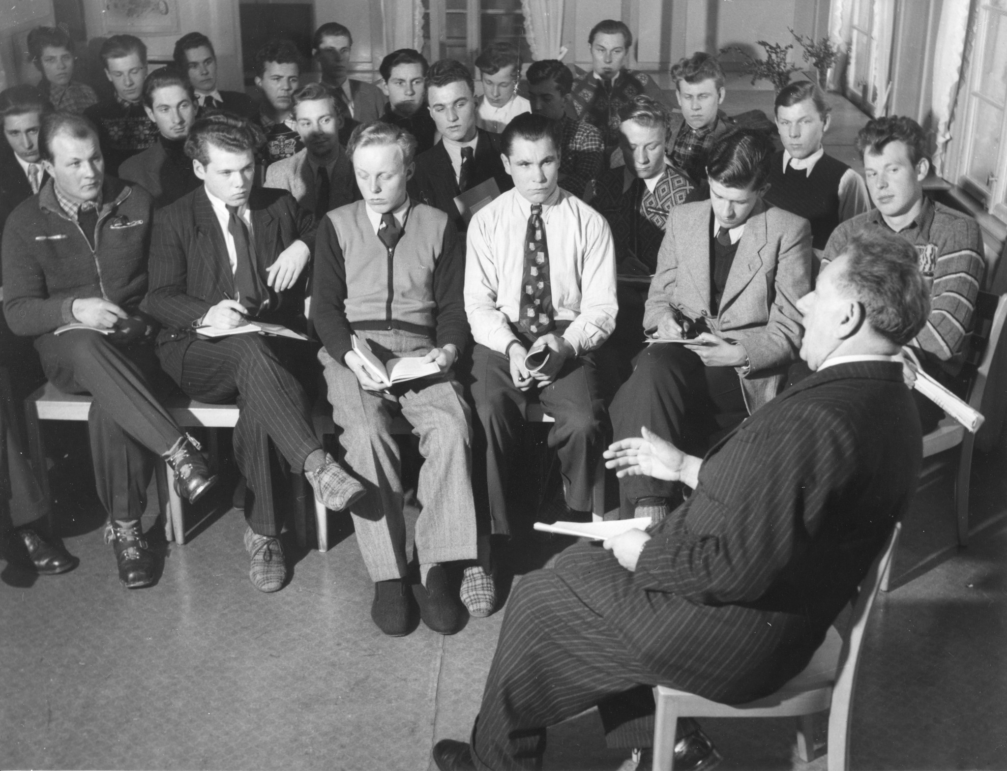 Erholungsaktion für jugendliche deutsche Flüchtlinge im Ferienhaus Lindenbühl 1952/1953; ein Betreuer bespricht mit Jugendlichen eine Lektüre