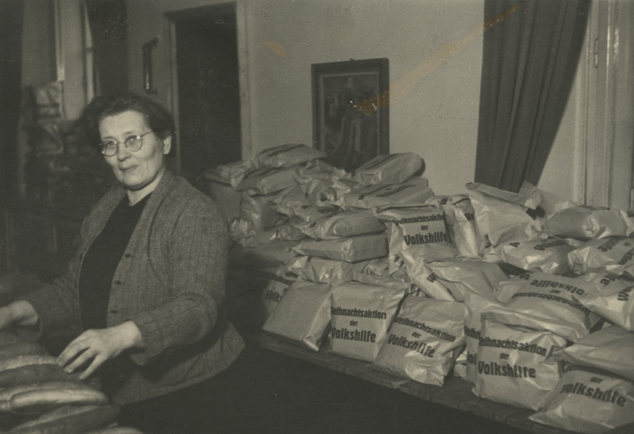 "Weihnachtsfeier 1947"; eine Frau bereitet Säcke der Weihnachtsaktin Volkshilfe vor, die später verteilt werden