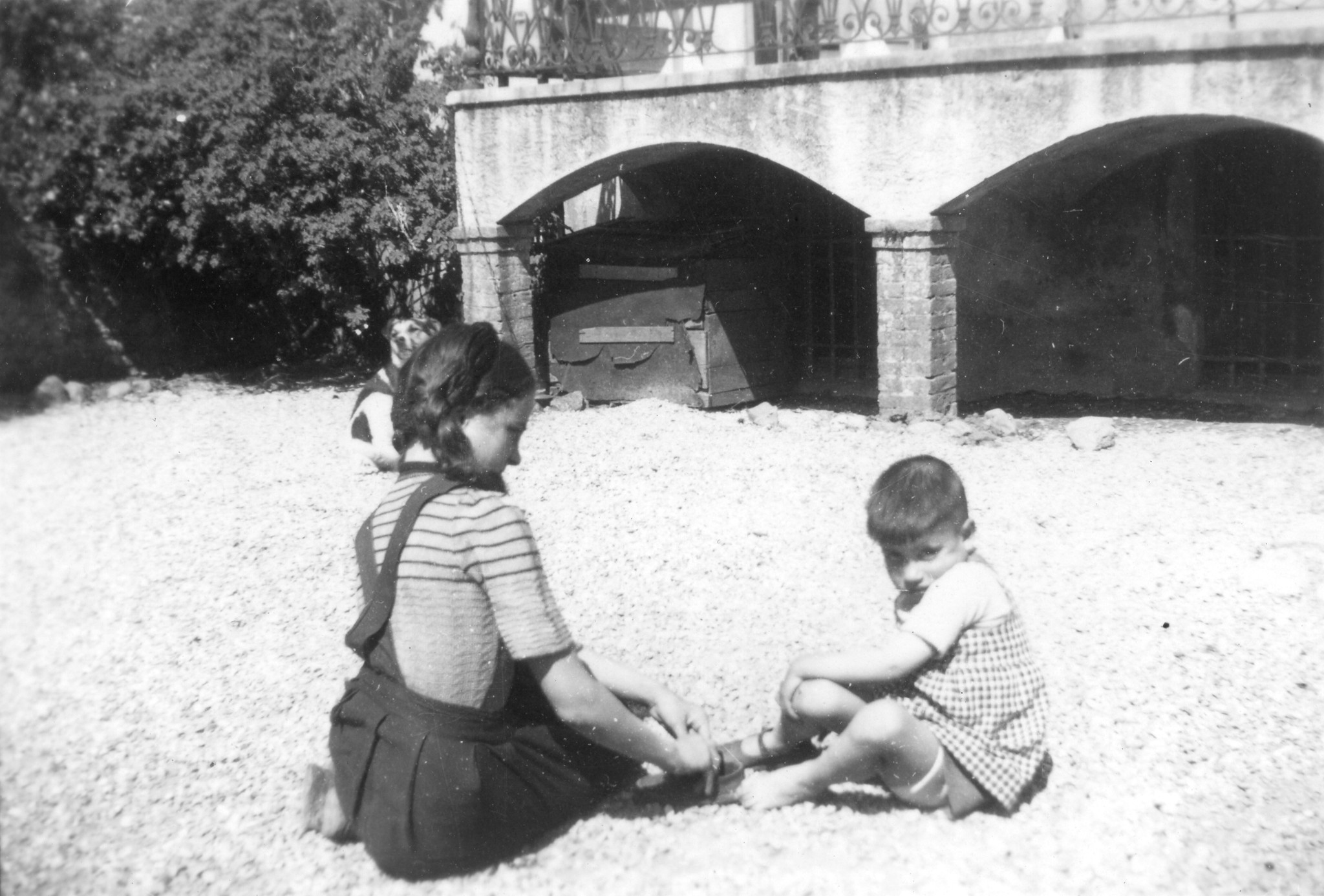 Ein Mädchen spielt mit einem Jungen auf einem Kiesplatz
