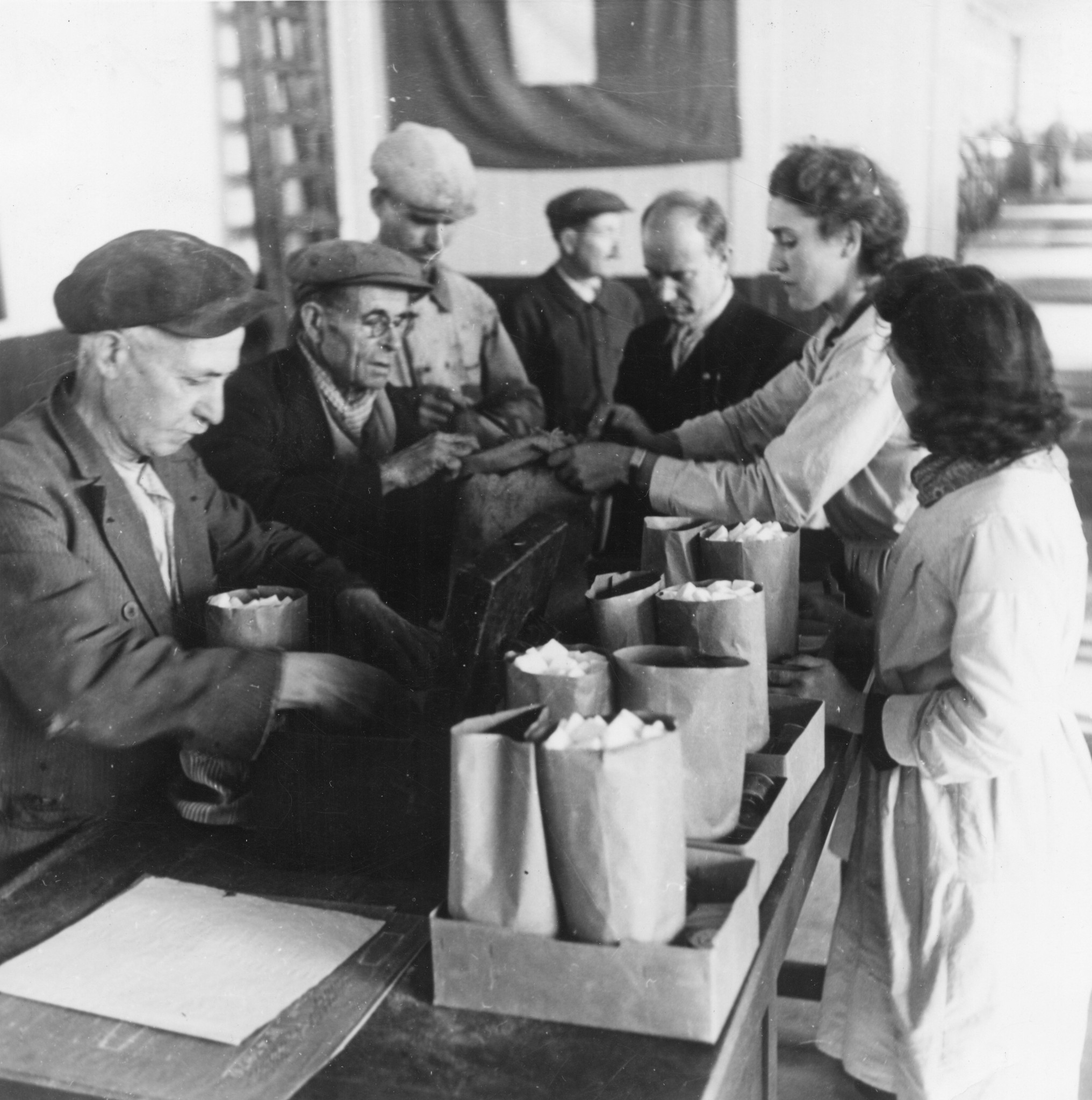 "Lyon, Oktober 1944. Französische Arbeiter und Arbeiterinnen der Fabriken Berliet nehmen Lebensmittel des SAH in Empfang."