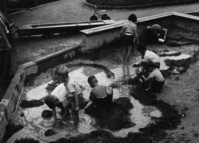 "Zug" - Kinder beim Spielen mit Sand und Wasser; um 1960
