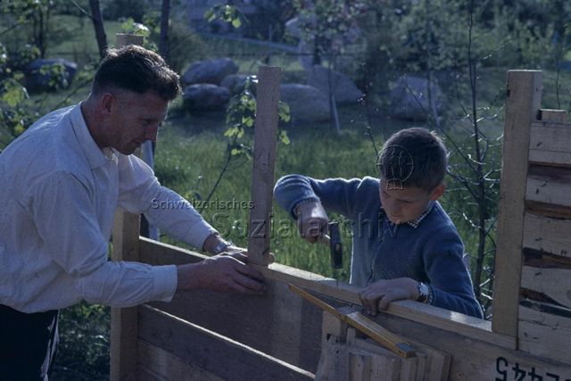 "Robinsonspielplatz" - Vater und Junge beim Bauen einer Hütte; um 1970
