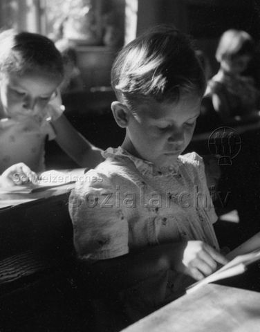 Mädchen liest im Schulunterricht in einem Buch; um 1970