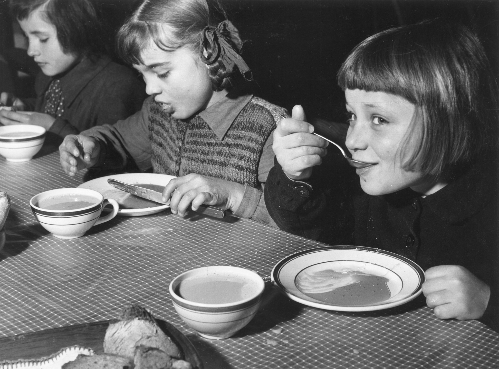 Drei Mädchen essen Suppe und trinken Ovomaltine