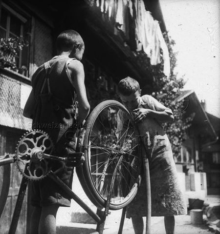 Jugendherberge Rotschuo, Gersau - Zwei Jungen beim Reparieren eines Fahrrads; um 1955