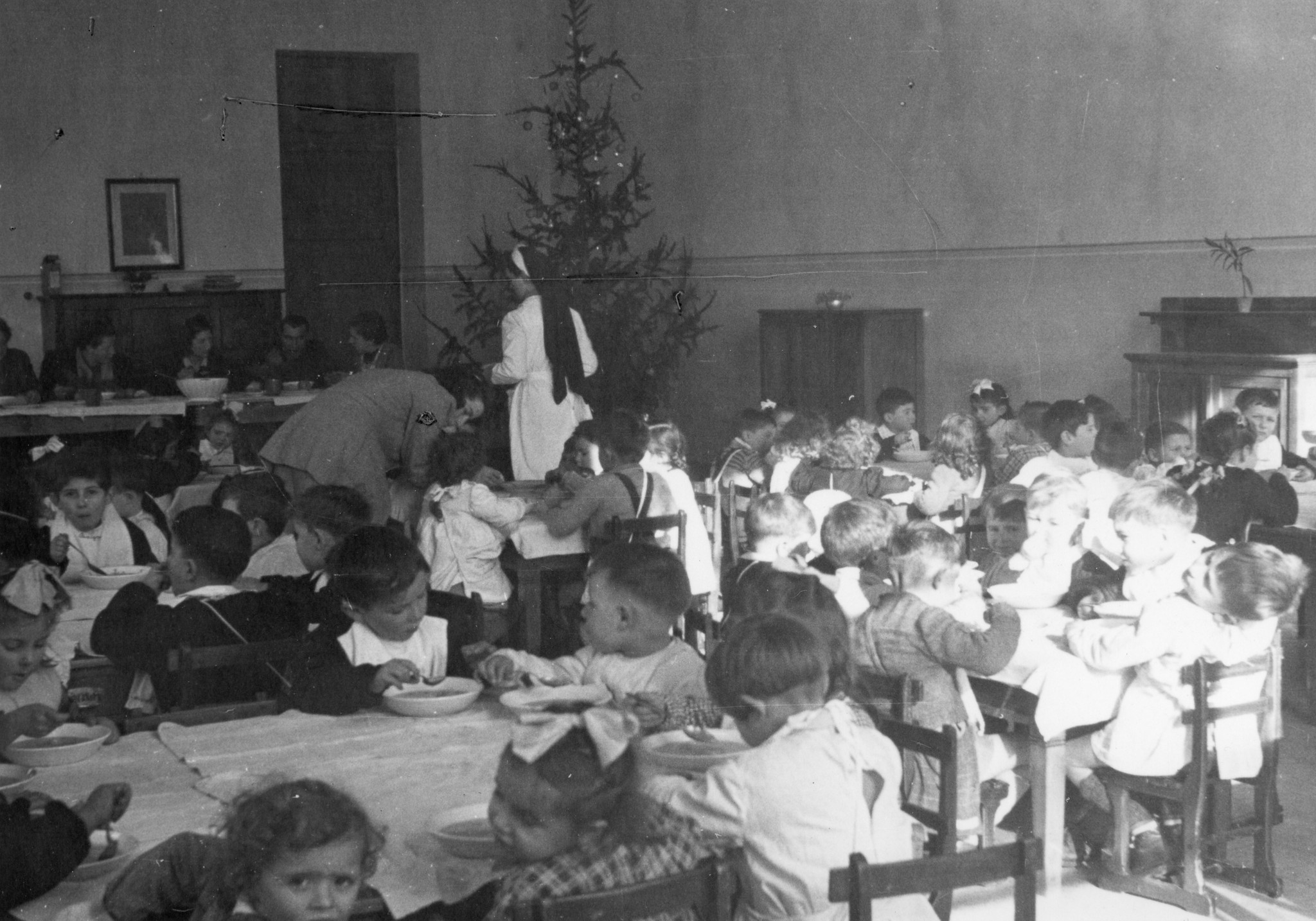 "Milano, Januar 1946. L'Asilo italo-suisse"; Kinder essen im Speisesaal Suppe, im Hintergrund steht ein Christbaum