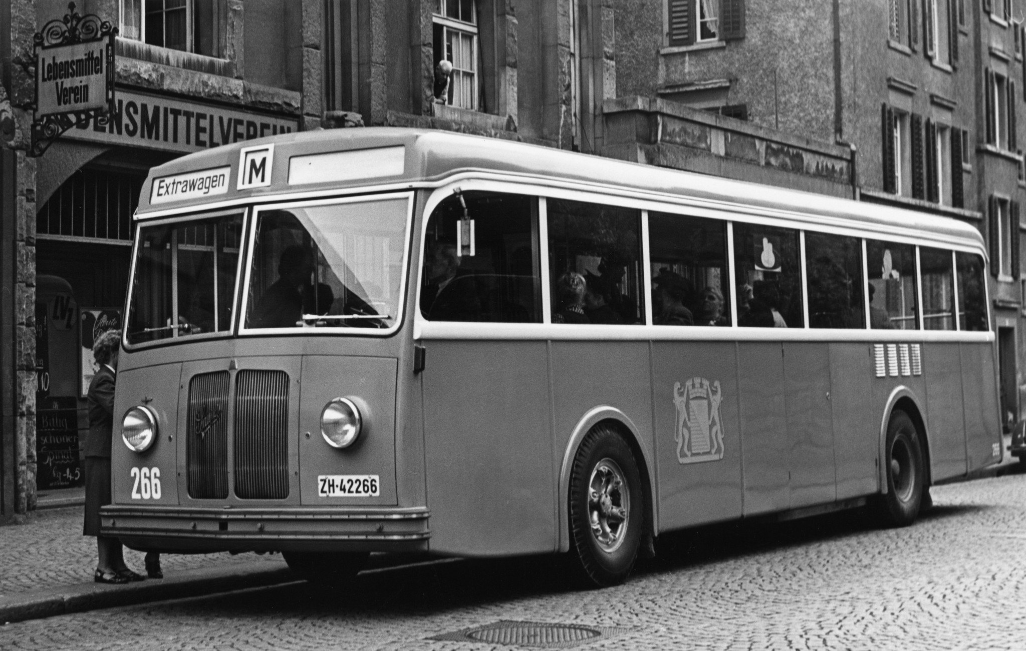 Mitarbeiterversammlung 1940er / 50er Jahre: Extrawagen der städtischen Verkehrsbetriebe vor einem Verkaufslokal des Lebensmittelvereins Zürich