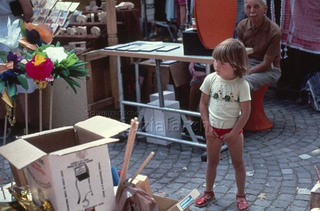 "Blumenbindeaktion Predigerplatz", Zürich - Kleines Kind, gebastelte Blumen; um 1980