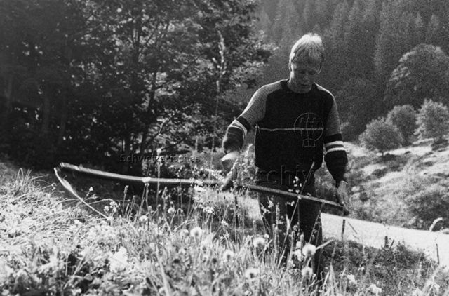 "Aktion 7" - Jugendlicher bei der Arbeit mit der Sense; um 1980