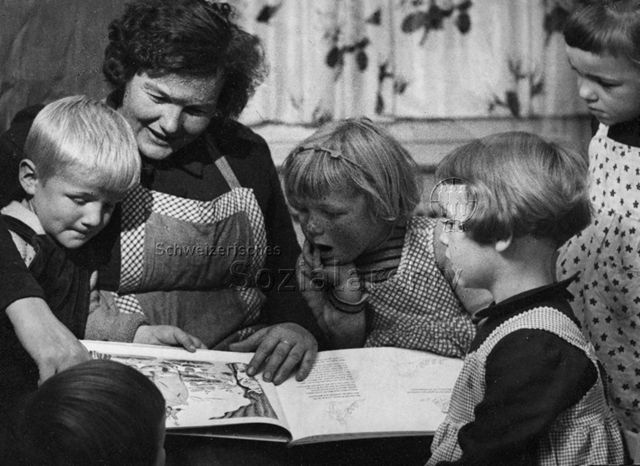 "Erzählen mit Bilderbuch" - Kindergärtnerin und Kinder; um 1960