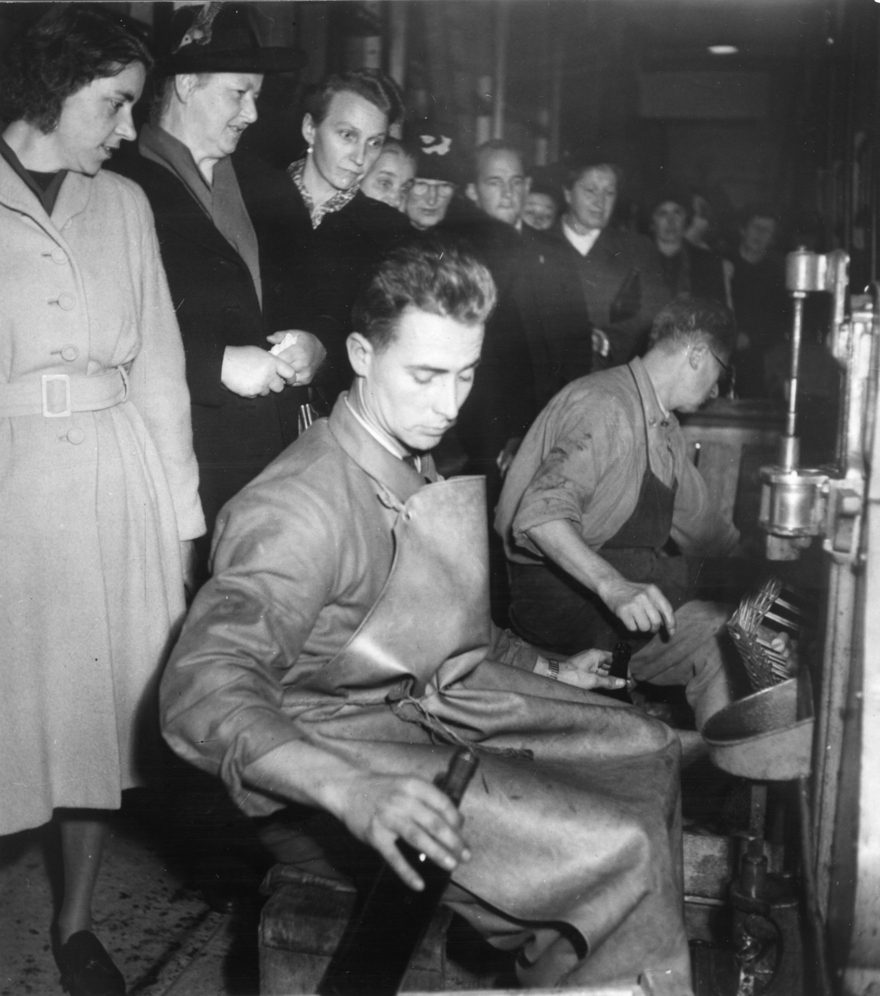 Betriebsbesichtigungen 1930er / 40er Jahre: Frauen schauen Männern beim Verkorken von Weinflaschen zu
