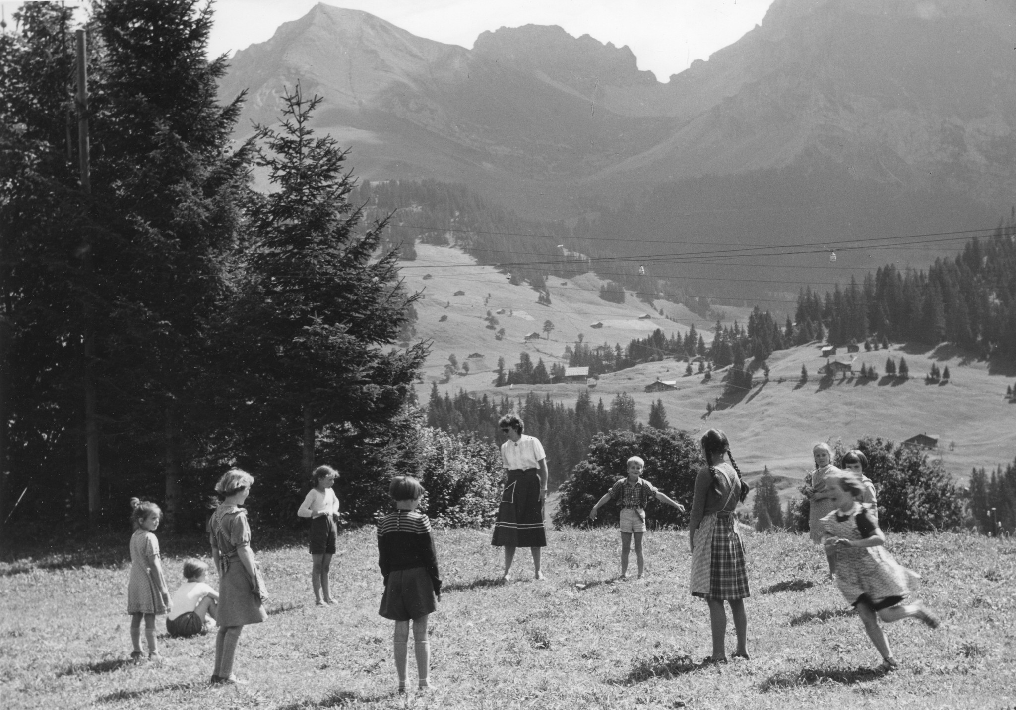 Kinder spielen mit einer Erzieherin ein Kreisspiel (de Fuchs gaht ume..)