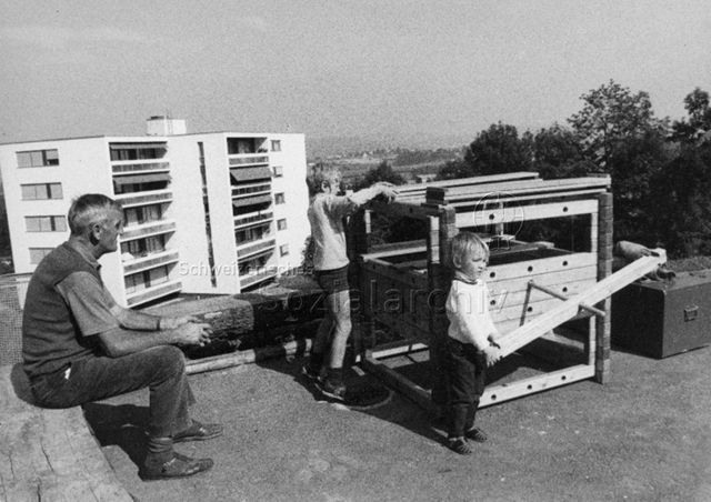 "Bauelemente, Siedlungsspielplatz Adliswil" - spielende Kinder, ein Mann sitzt daneben; 1971