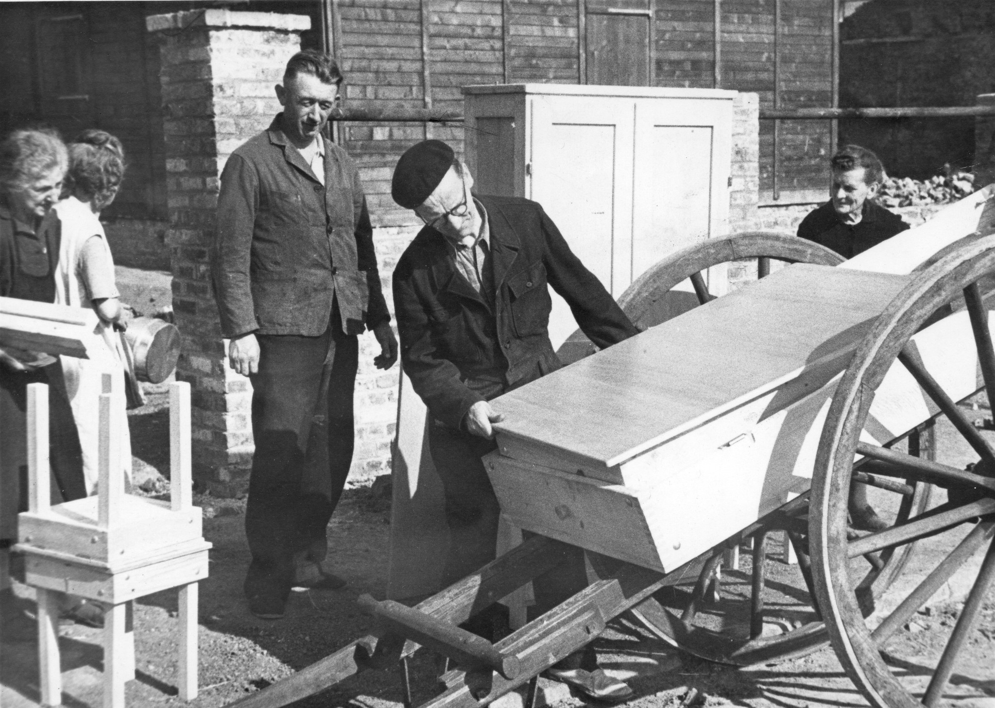 "Fives [Stadtviertel von Lille, Nord-Pas-de-Calais] Bénéficiaire de mobilier AERMO", Arbeiter und Arbeiterin laden einen Möbelstück auf, vermutlich aus dem SAH-Sozialzentrum, um 1946