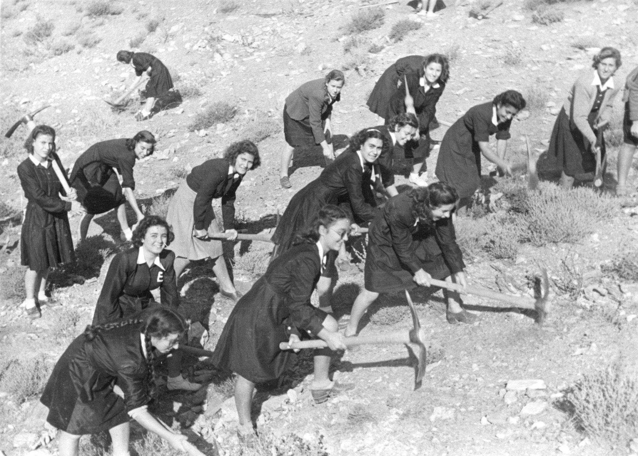 "Reconstruction of roads done by young people of Greece voluntarily. La jeunesse grecque contribue volontairement à la reconstruction des routes de son pays". Junge Frauen leisten Freiwiligenarbeit um eine Strasse wiederherzustellen