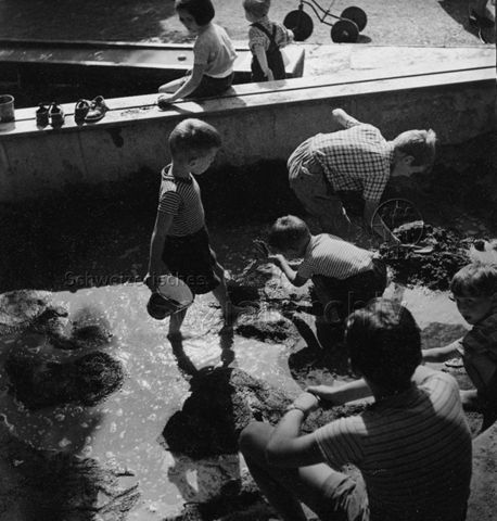 "Zug", Spielplatz - Kinder beim Spielen mit Sand und Wasser; um 1965