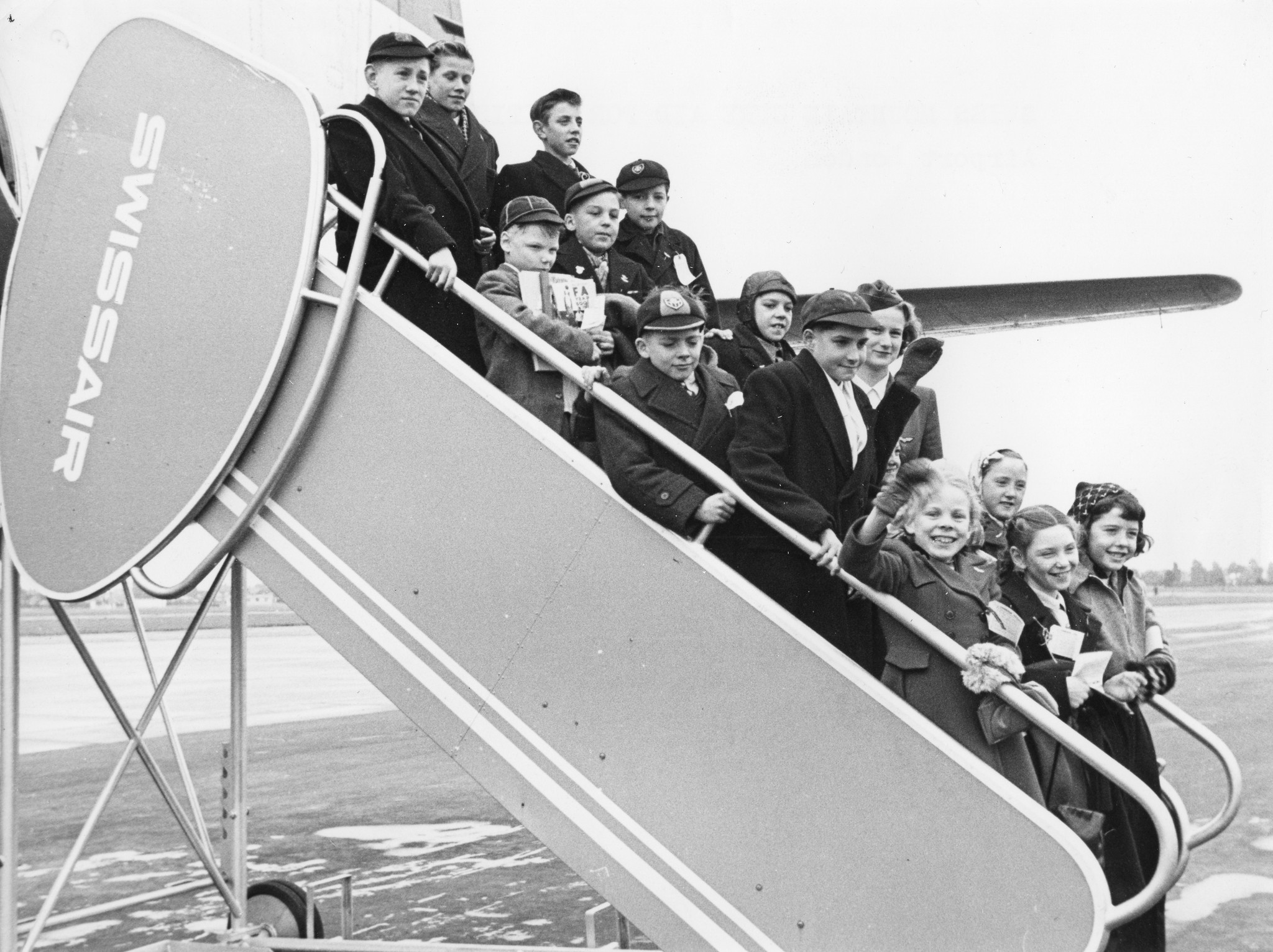 "Swiss Mountain Cure Aid for British Children: Airport London Okt. 1950"; Kinder auf einer Swissair-Rolltreppe stehend