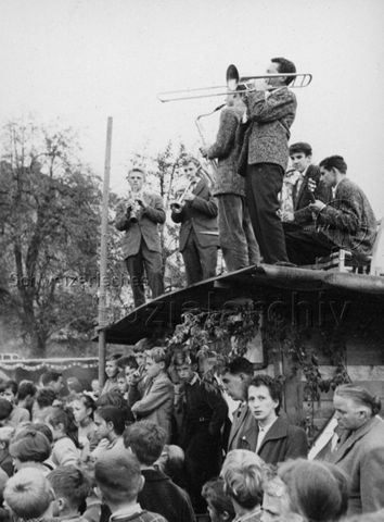 Aufführung, wahrscheinlich Kinderzirkus Robinson - Musikalische Darbietung vom Dach eines Häuschens; um 1970