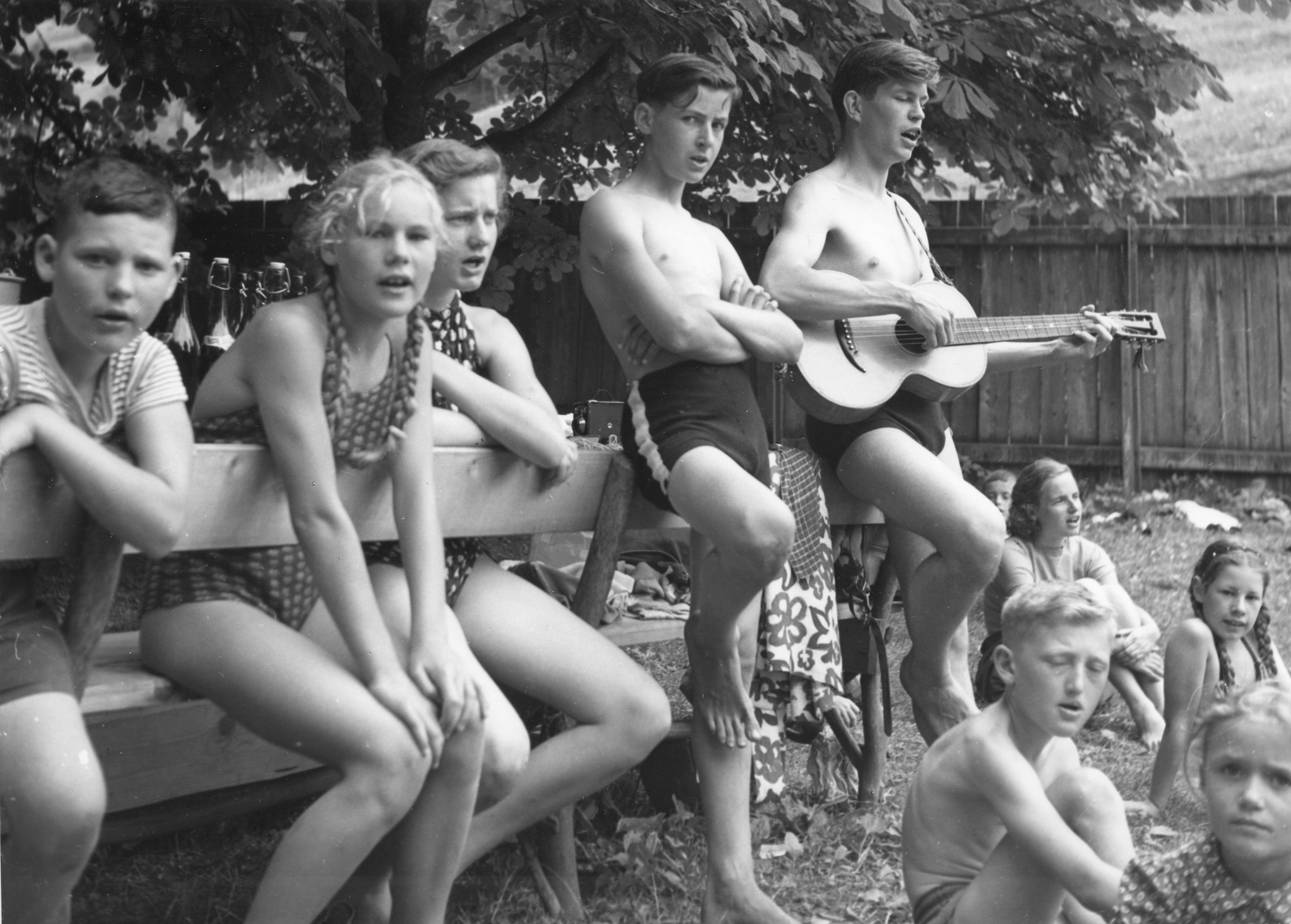 Ferienkolonie Landmark: Ein Jugendlicher spielt Gitarre und die restlichen Kinder singen