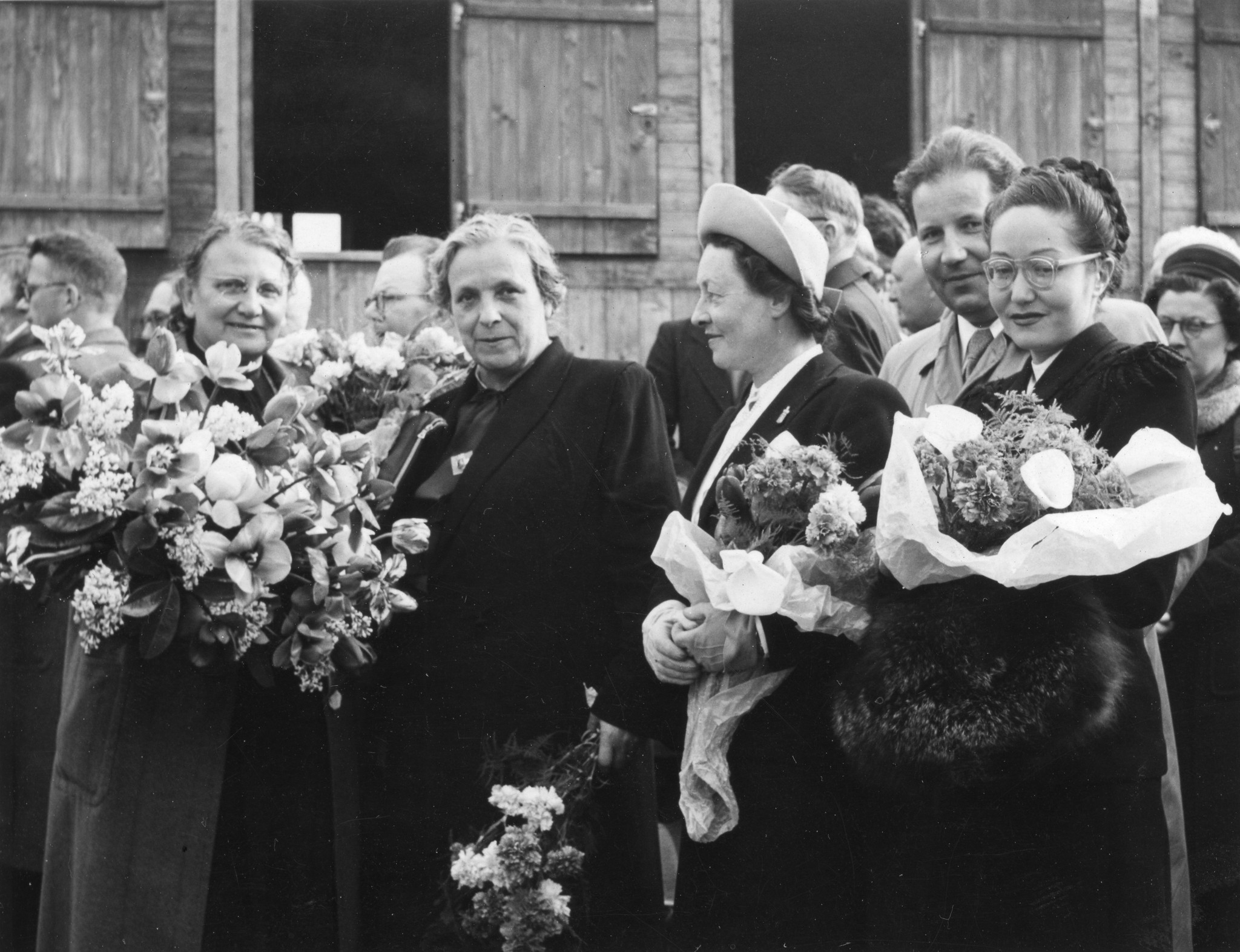Regina Kägi-Fuchsmann, Margaretha Kissel-Brutschy und weitere Personen mit Blumensträussen posierend, vermutlich nach einer Veranstaltung in Saint-Lô