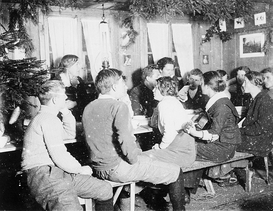 Weihnachtsfest der Wandervogelortsgruppe Seon: Wandervögel sitzen am Tisch; ein Mädchen Gitarre spielend (1915)