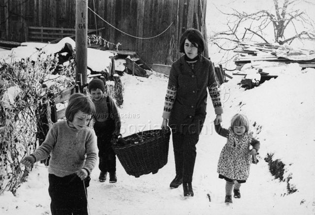 Praktikantinnenhilfe - Praktikantin und drei Kinder holen Feuerholz; um 1965