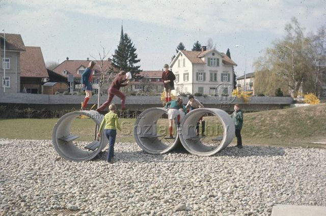 "Siedlungsspielplatz Bundespersonal, Romanshorn" - Kinder beim Spielen auf Betonröhren; um 1975