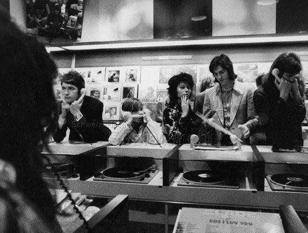 Jugendliche im Plattenladen hören Musik auf Vinyl; um 1975