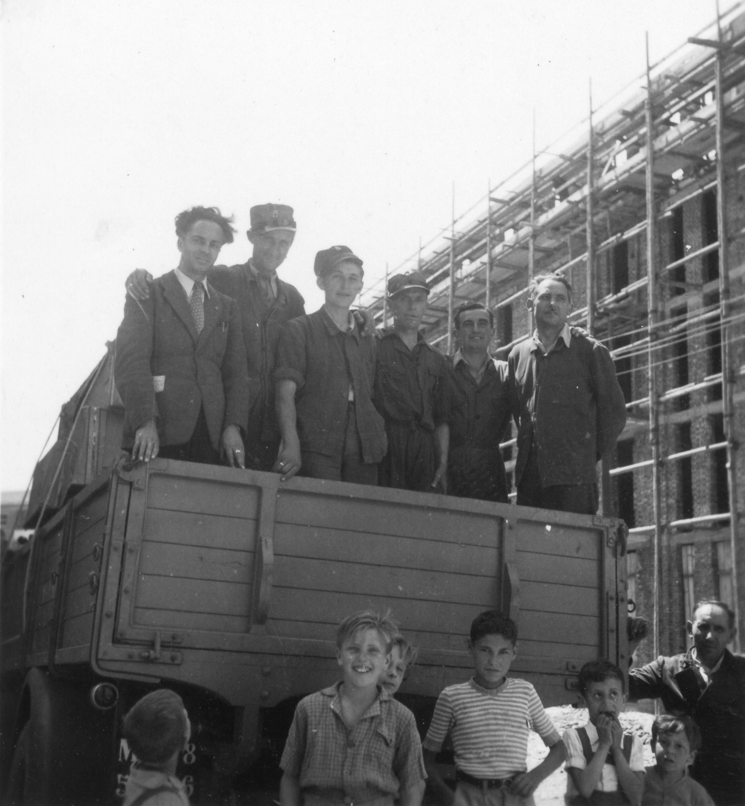 "Milano, Sommer 1946. AERMO-Möbelverteilung und Innenaufnahmen. Die Neubauten sind in aller Eile aufgebaute Mietskasernen (Case Popolari) für Ausgebombte."; Kinder stehen auf einem Transporter