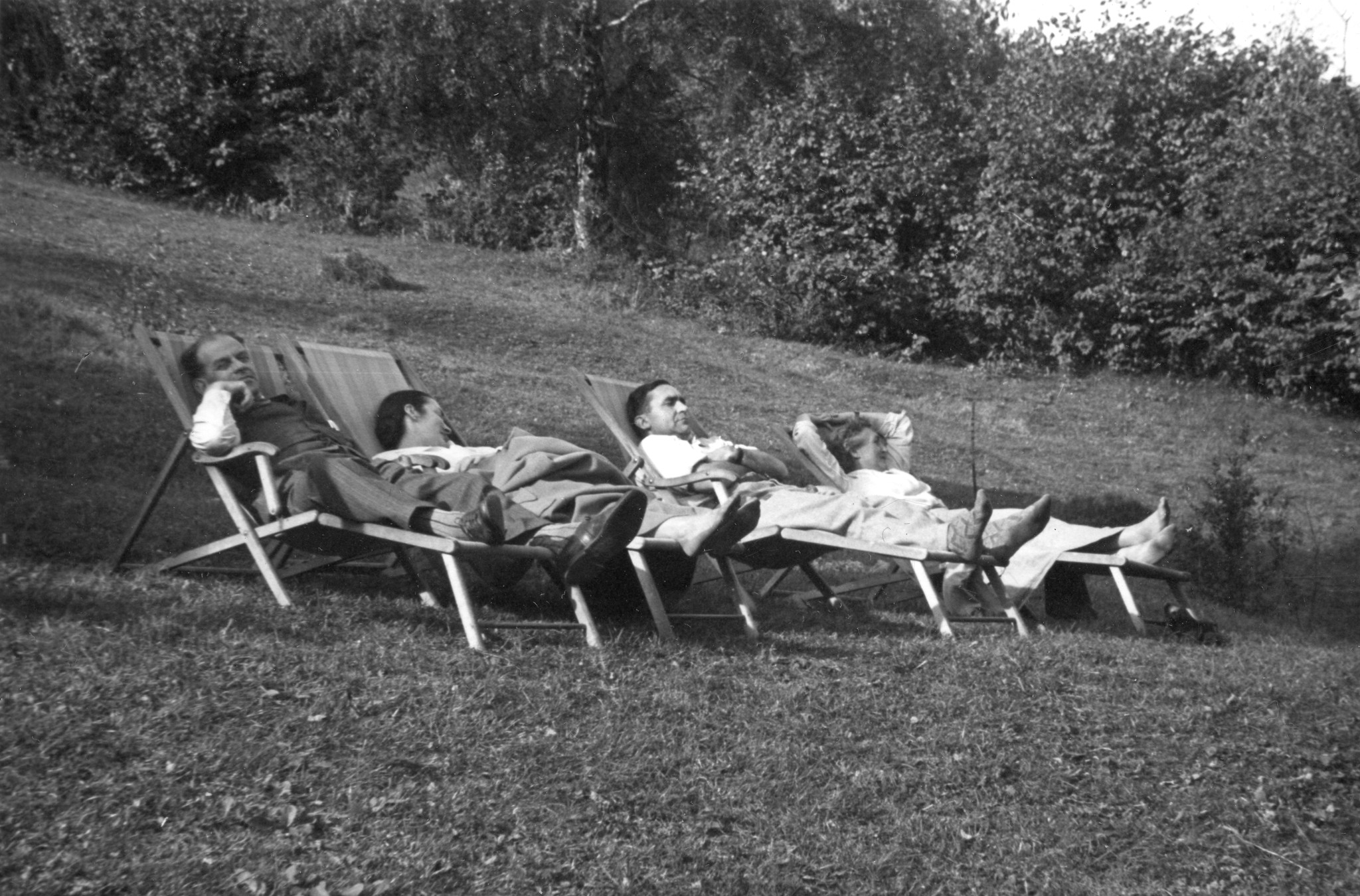Sammellager im Haus der SMUV Sierre-Aktion zugunsten notleidender Gewerkschafter 1951; vier Personen liegen in Liegestühlen auf einer Wiese