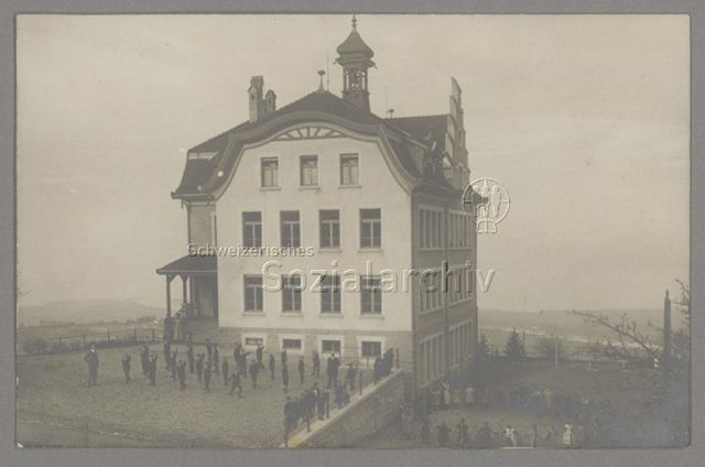 Schulhaus in Heiden mit getrennten Pausenplätzen für Knaben (links) und Mädchen, um 1920