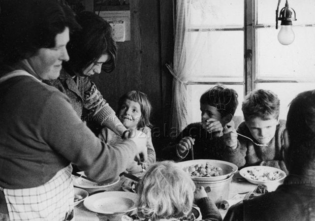 Praktikantinnenhilfe - Mutter und Praktikantin kümmern sich darum, dass alle satt werden; um 1965