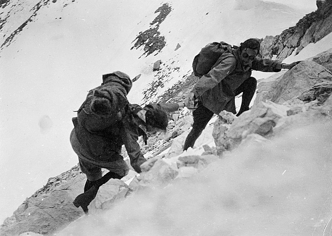 Zwei Wandervögel wandern über den Julier und Sprungpass (?) und helfen sich gegenseitig (vermutlich) beim Klettern auf steinigem Gel