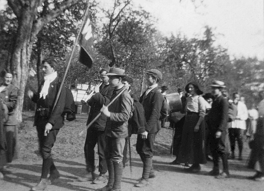Wandervögel der Ortsgruppe Zürich auf der Strasse, ein Wandervogel Trompete spielend (1913)