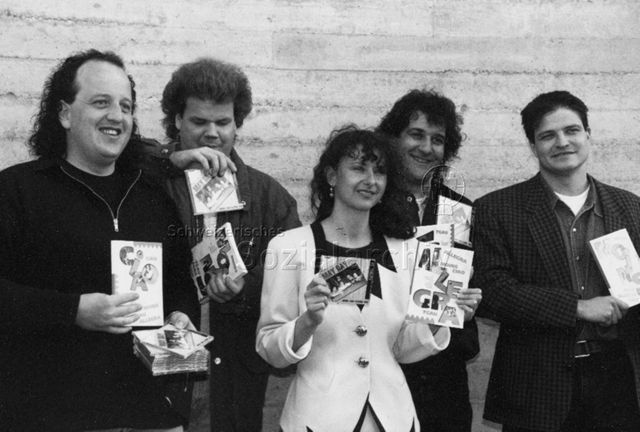 Veranstaltung - Band 'May Day' und eine Frau präsentieren die Broschüre 'Moins, tgau, allegra, ciao', eine Broschüre für Jugendliche in Graubünden und eine dazugehörende CD der Band; um 1995
