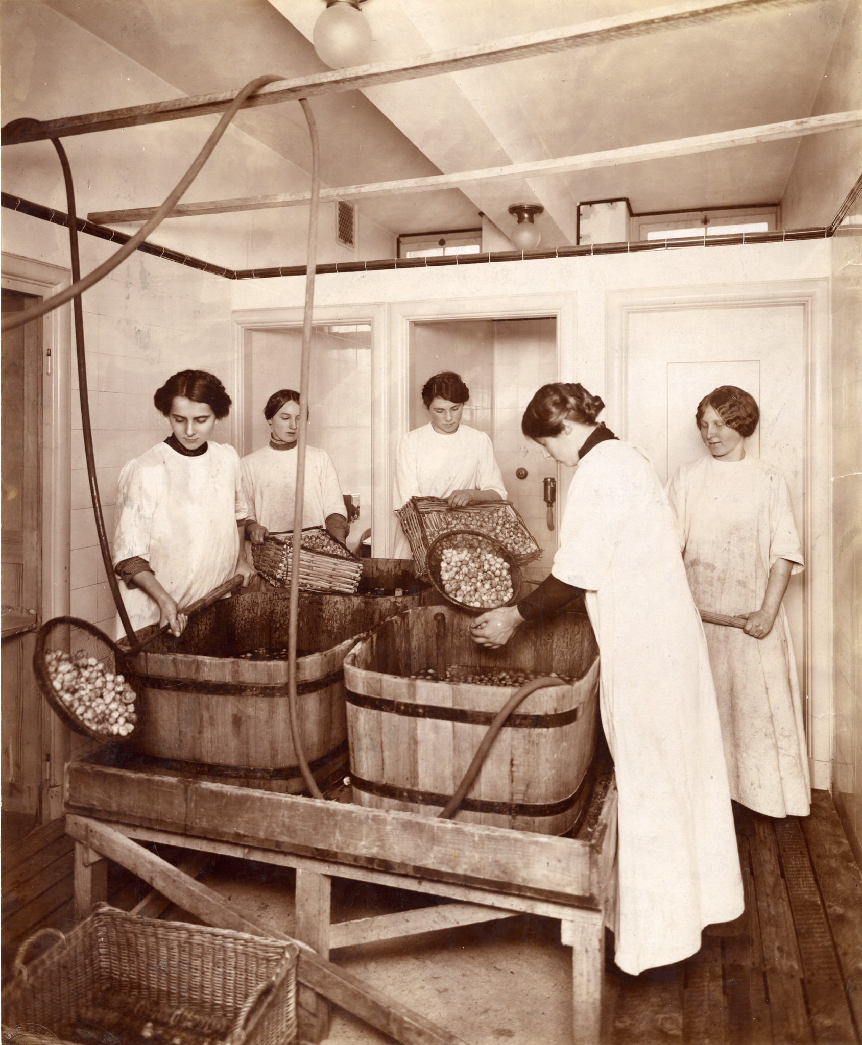 Frauen waschen Rosenkohl in Holzbottichen