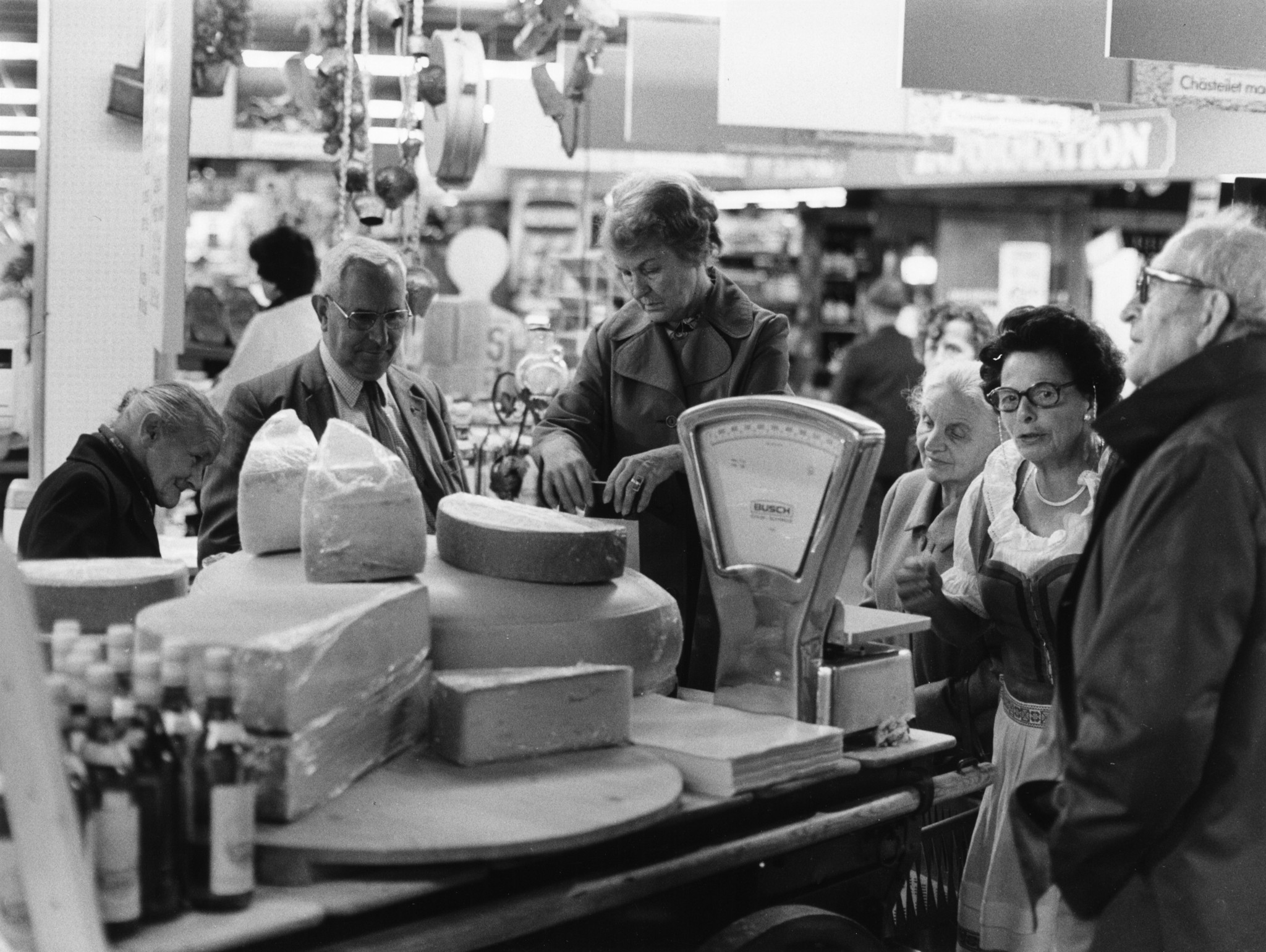 Werbeaktion in einem Laden des Lebensmittelvereins Zürich: Käse-Abstechen und Schätzen des Gewichts, Angestellte und Kunden