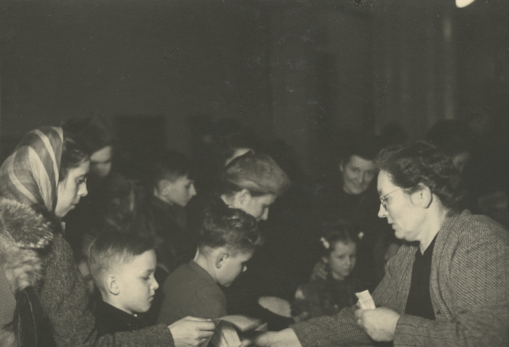 "Weihnachtsfeier 1947"; eine Frau sammelt Gutscheine für die Säcke der Weihnachtsaktion