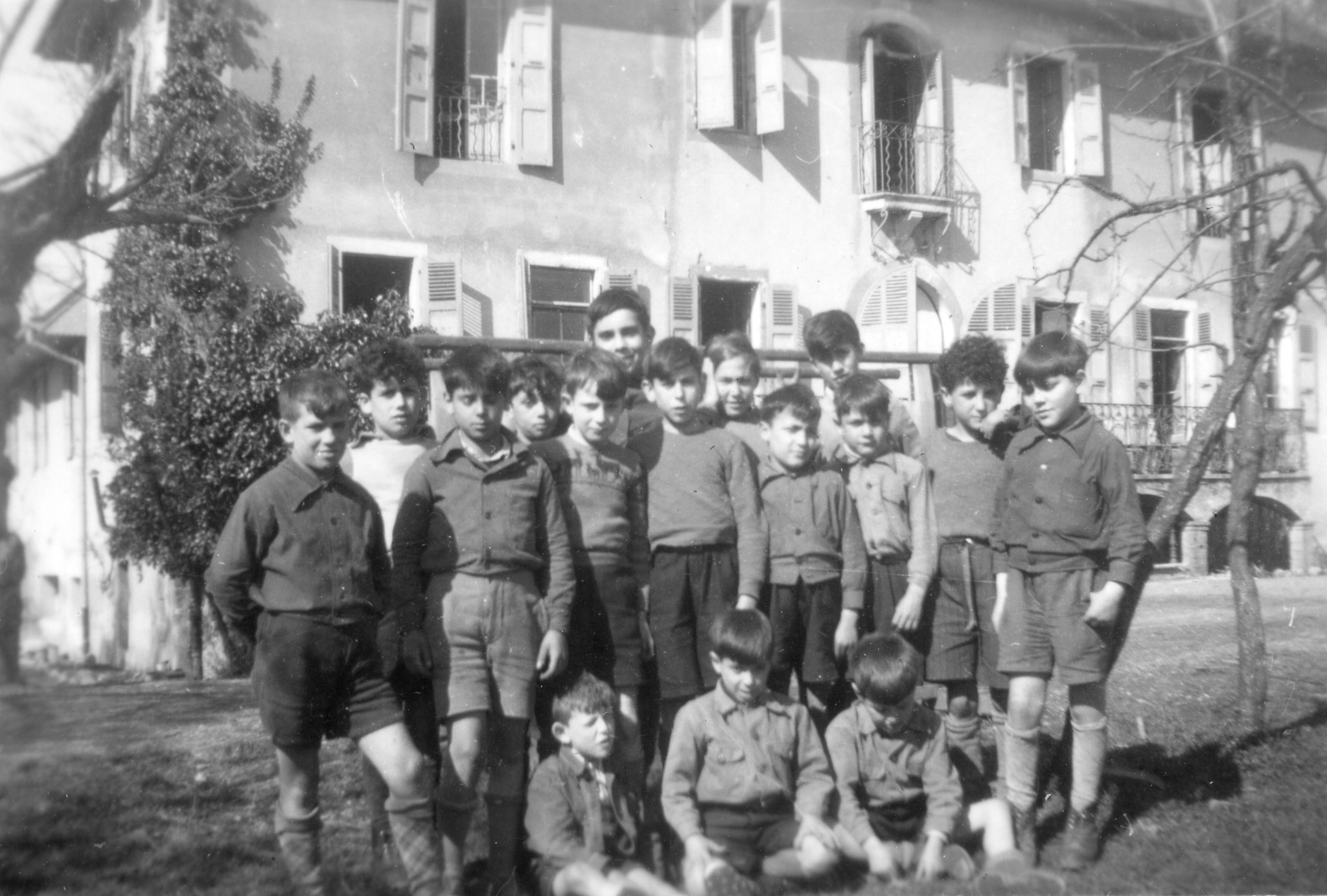 Gruppenfoto von Knaben vor einem Haus