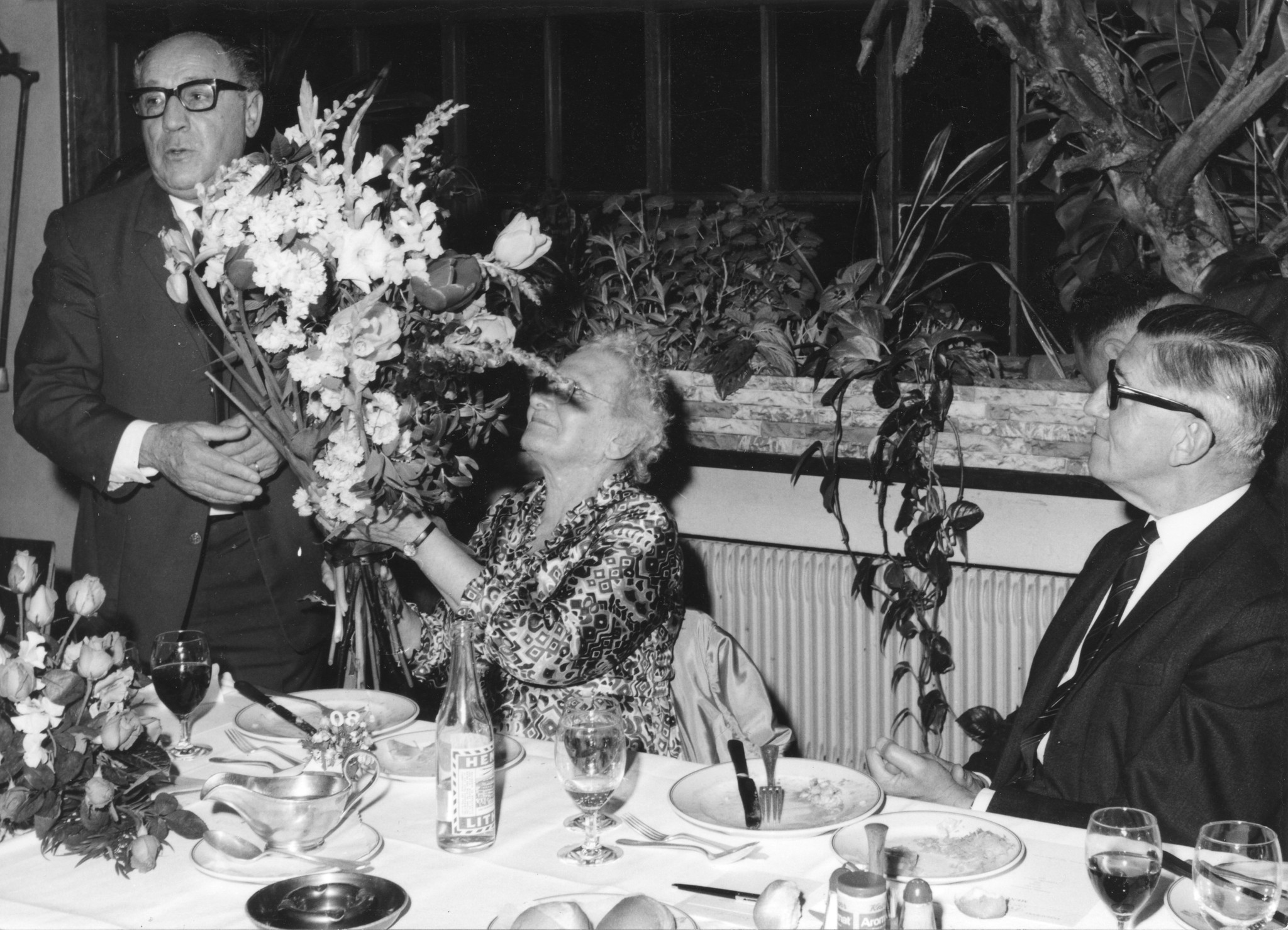"80. Geburtstag Regina Kägi 08.05.1969"; ein Mann übergibt Regina Kägi-Fuchsmann einen Blumenstrauss