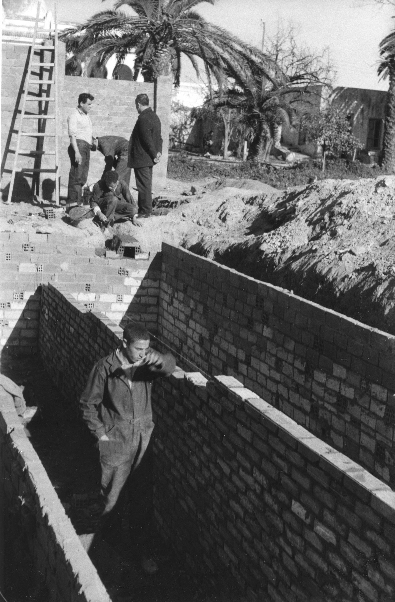 Ein Lehrling mauert das Fundament eines Gebäudes